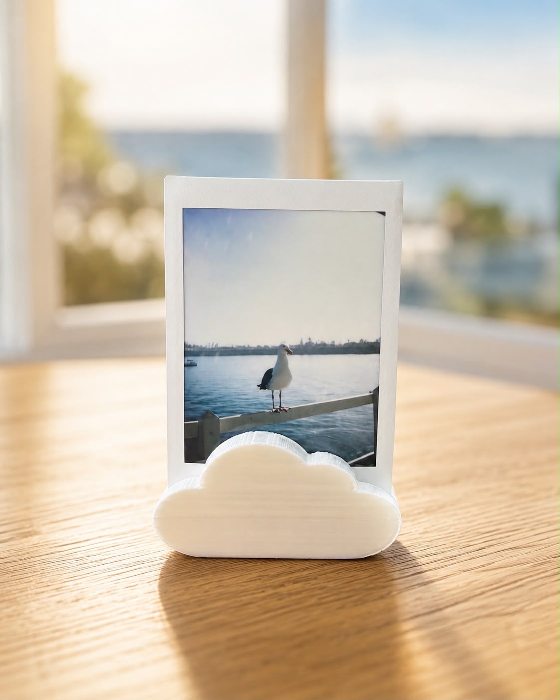White cloud-shaped photo holder displaying an instant photo on a wooden table