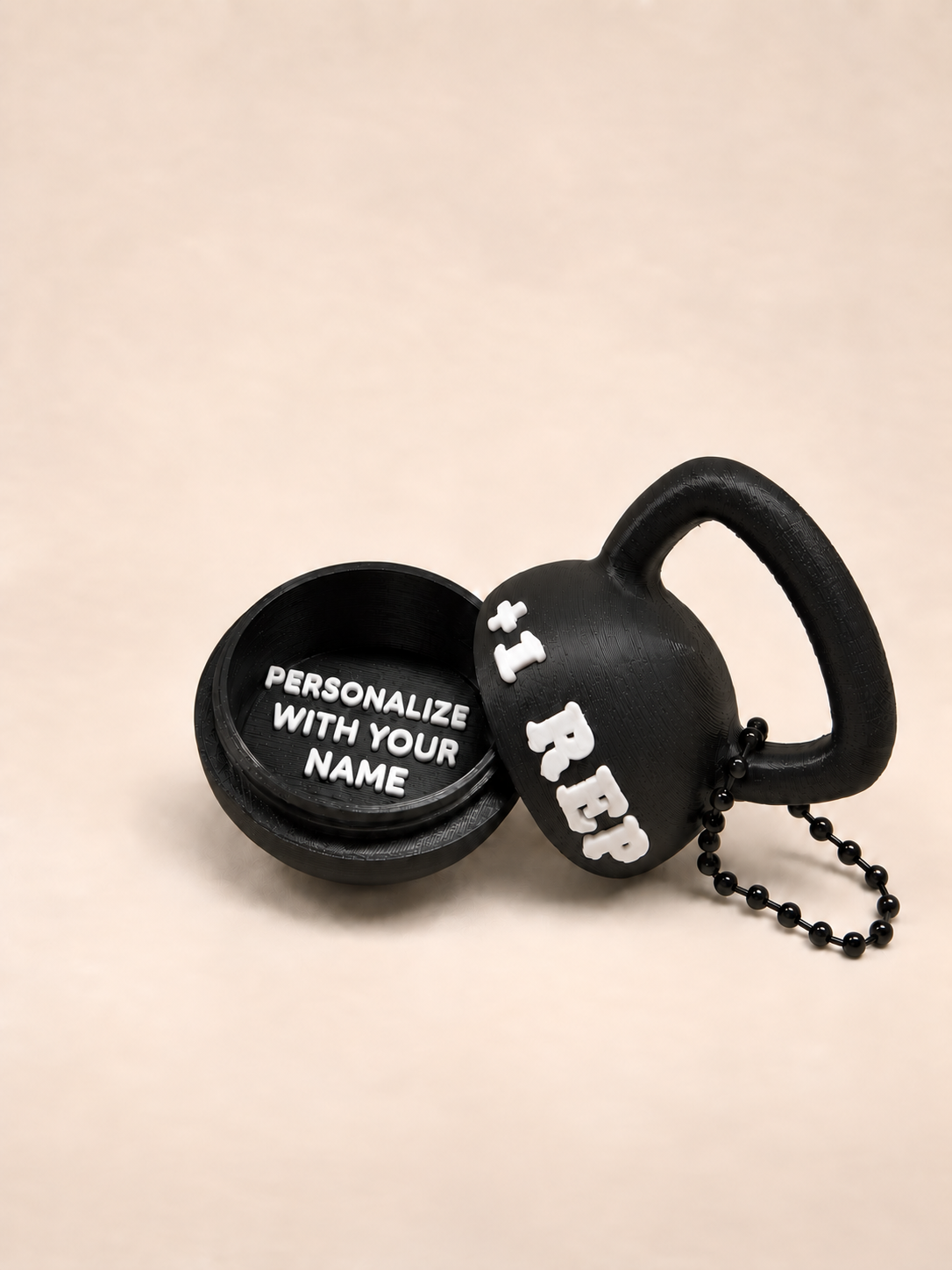 Black kettlebell ring box keychain opened to show a personalized name compartment and +1 REP lettering