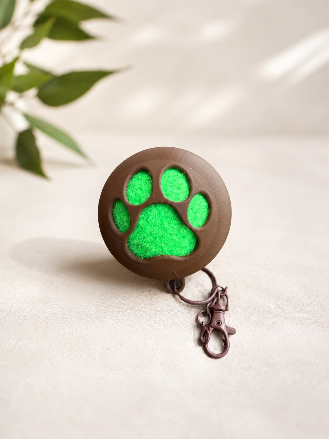 Brown 3D-printed paw scrubber keychain with green scrubber insert