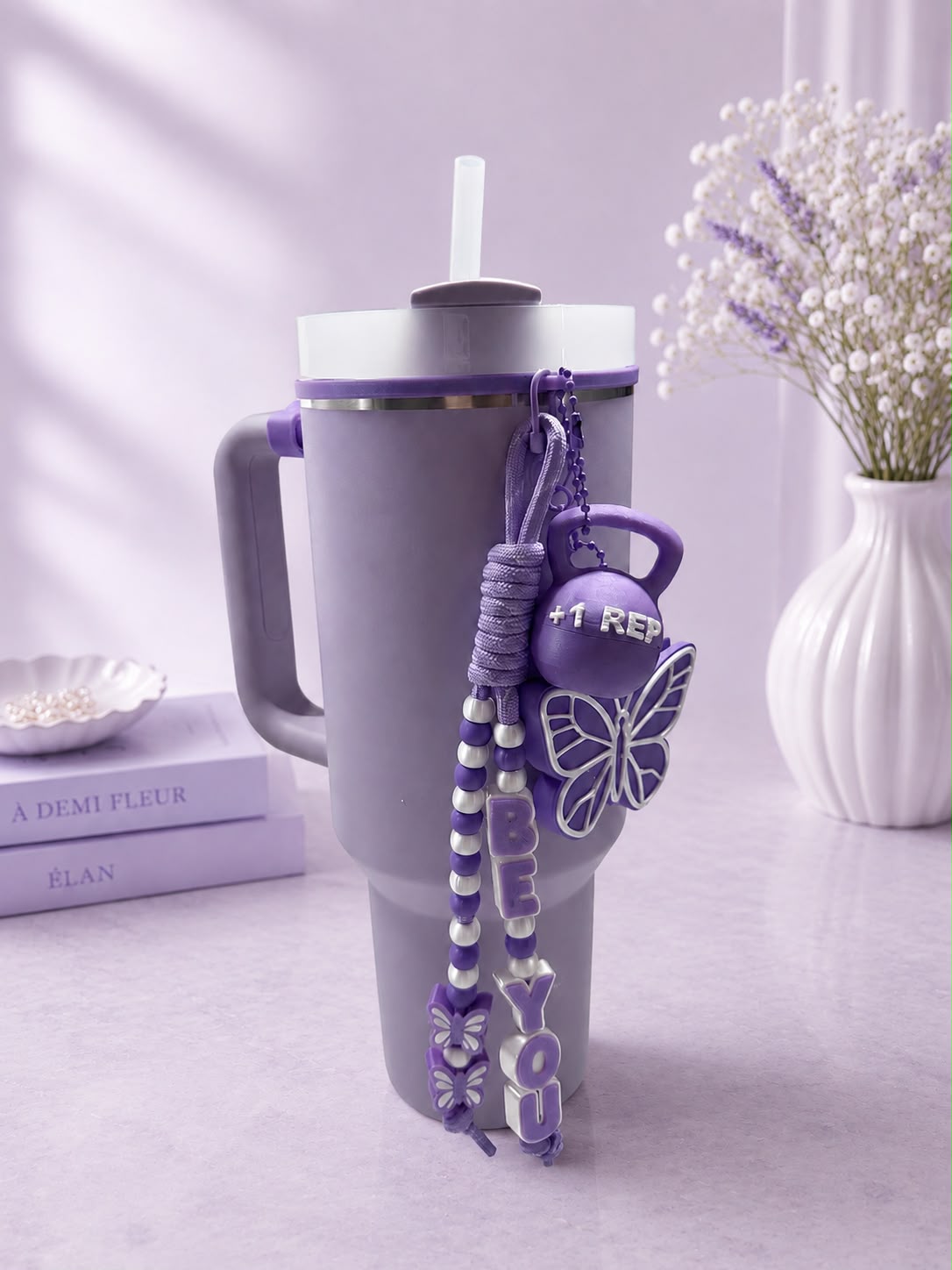 Purple personalized tumbler charm set with name beads, butterfly and mini kettlebell charm on a tumbler